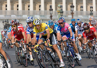 Carlos Sastre racing in yellow on the Champs Elysee